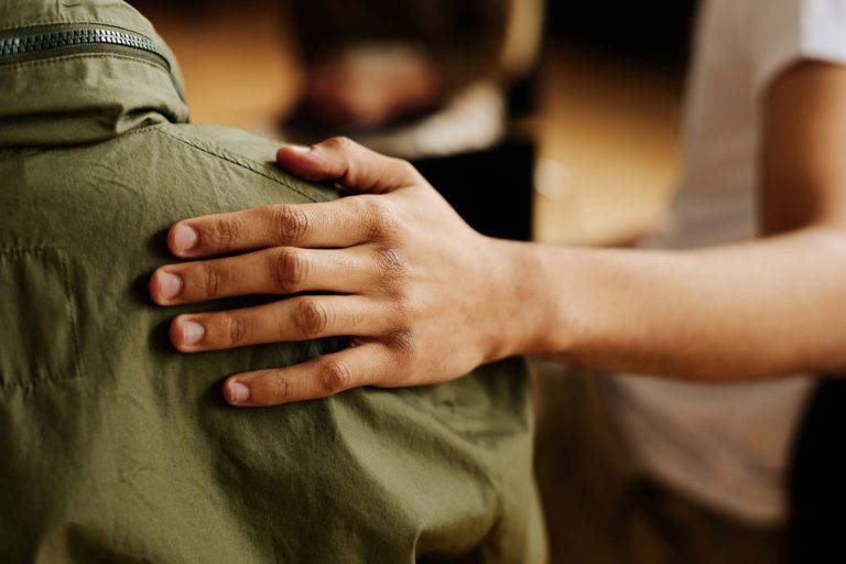 a HAND AGAINST A SHOULDER