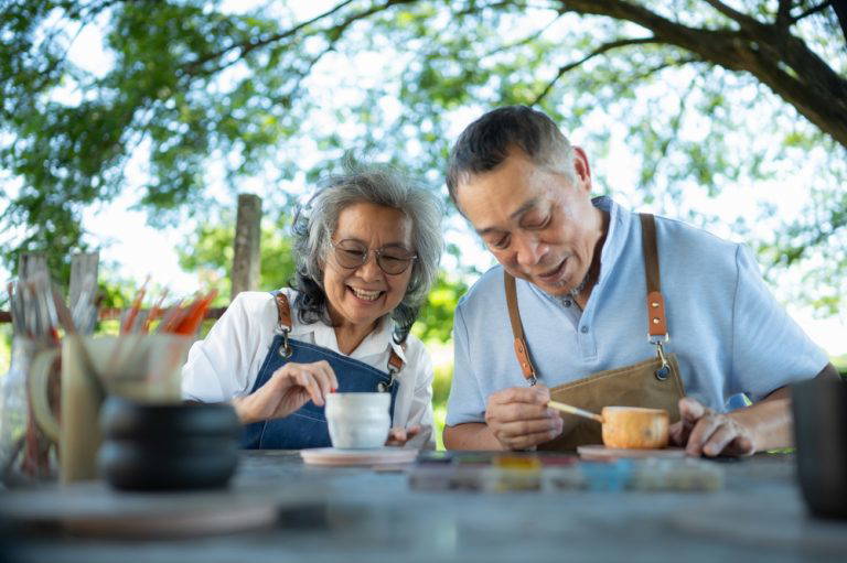 two older people doing art